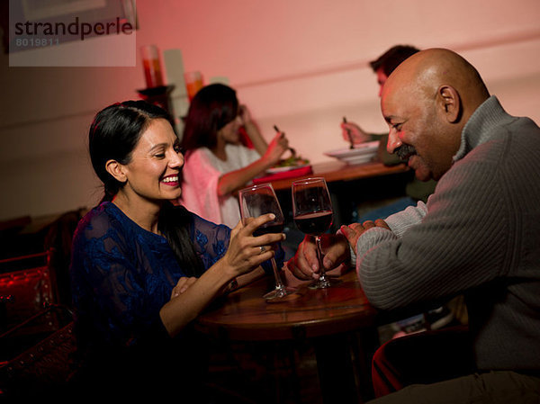 Paar genießt Wein im Restaurant  lächelnd