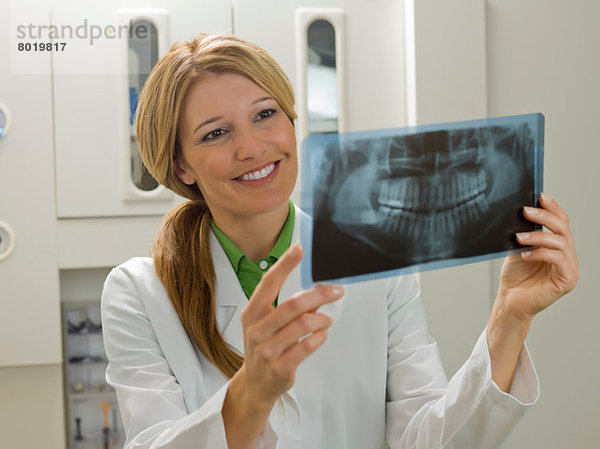 Zahnarzt beim Röntgen  lächelnd