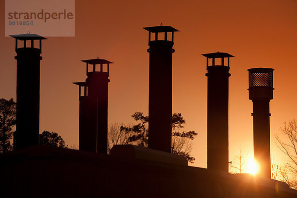 Silhouette von Gasleitungen in der Ölraffinerie bei Sonnenuntergang