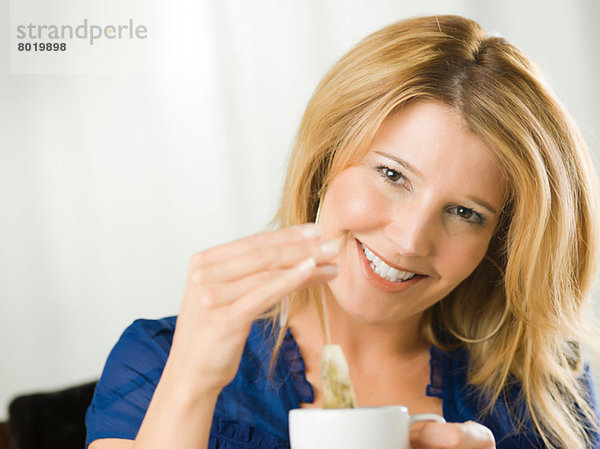 Mittlere erwachsene Frau hält Tasse und lächelt  Portrait