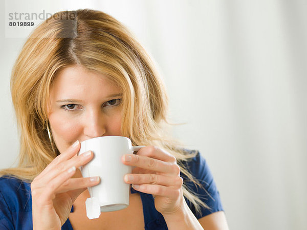 Mittlere erwachsene Frau trinkt aus Tasse  Portrait