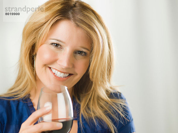 Mittlere erwachsene Frau mit einem Glas Wein  Portrait