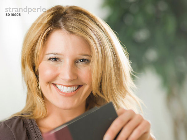 Mittlere erwachsene Frau mit Notizbuch und Lächeln