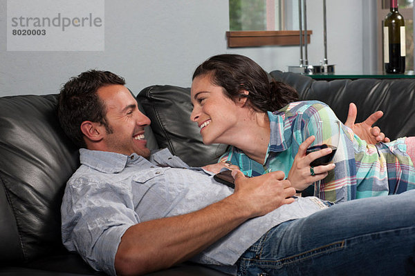 Junges Paar entspannt auf dem Sofa  lächelnd