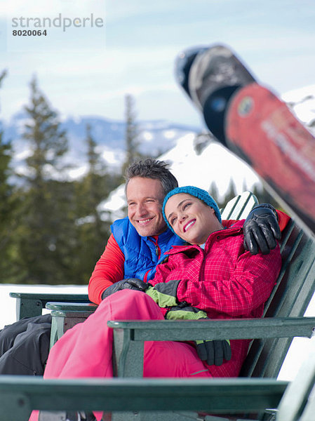 Erwachsener Mann und junge Frau entspannen gemeinsam im Skigebiet
