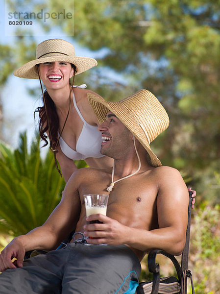Junges Paar mit Sonnenhut und Entspannung im Urlaub  Portrait