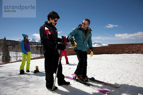 Erwachsener Mann mit Skilehrer auf der Piste