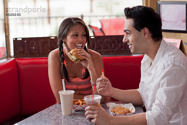 Junges Paar isst Fast Food im Diner