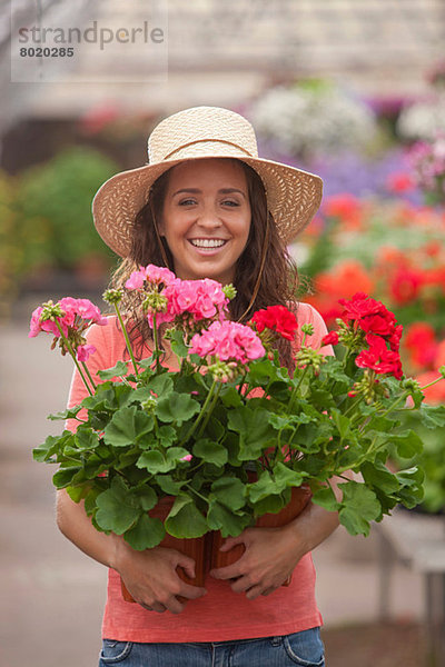 Junge Frau mit Pflanzen im Gartencenter  Portrait