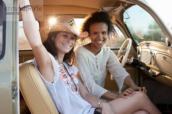 Junge Frauen sitzen im Auto auf Roadtrip  Porträt