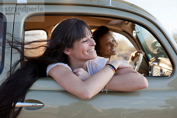 Junge Frauen  die mit dem Auto unterwegs sind  lächelnd
