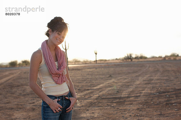 Junge Frau steht in der Wüste  Porträt