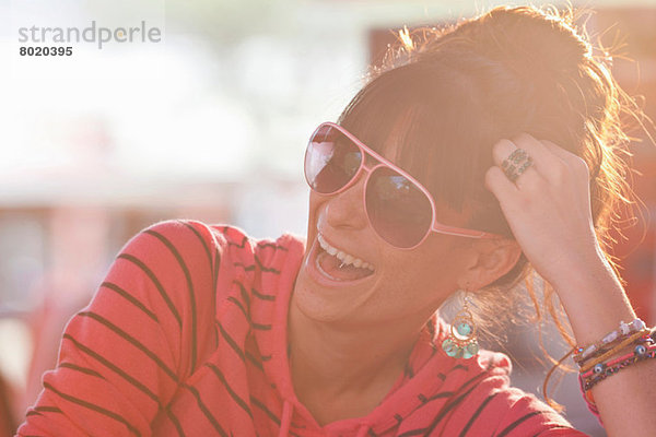 Junge Frau mit Sonnenbrille im sonnendurchfluteten Diner