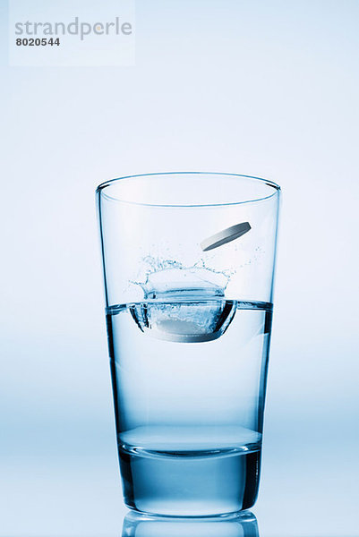 In ein Glas Wasser fallende Tabletten