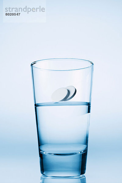 In ein Glas Wasser fallende Tabletten