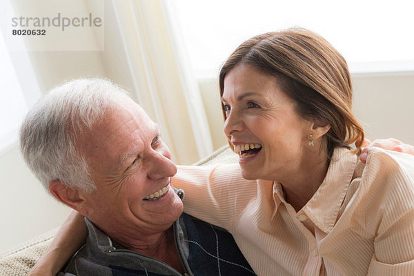 Reife Frau und älterer Mann umarmend  lachend