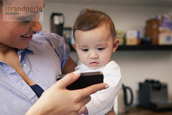Mutter zeigt Baby Girl Smartphone
