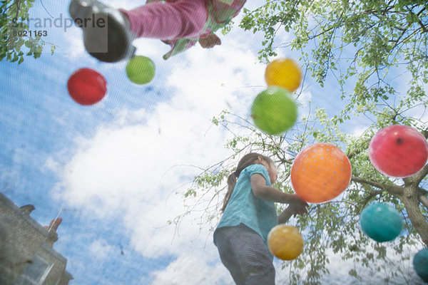 Junge Mädchen springen auf Gartentrampolin