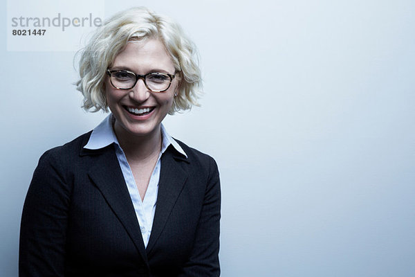 Studio-Porträt der blonden Geschäftsfrau lächelnd