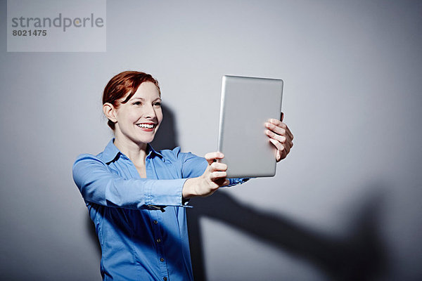 Studio-Porträt einer jungen Frau mit digitalem Tablett