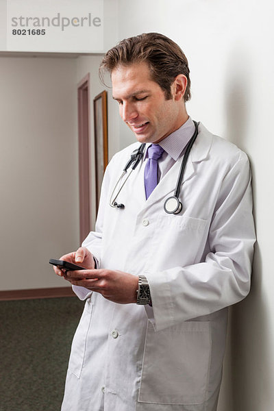 Arzt mit Handy im Krankenhausflur