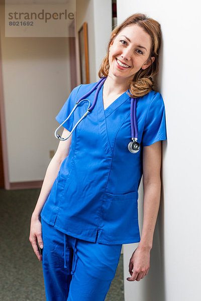 Krankenschwester in blauem Kittel im Krankenhausflur lächelnd  Portrait