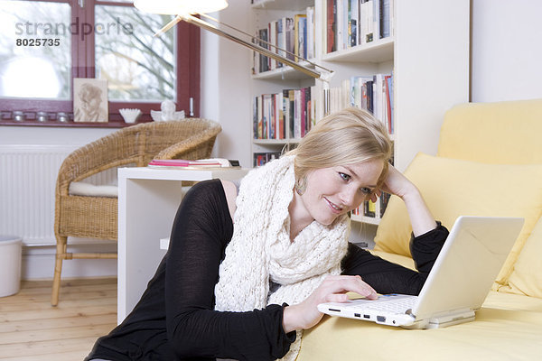 Junge Frau schaut in ihr Notebook