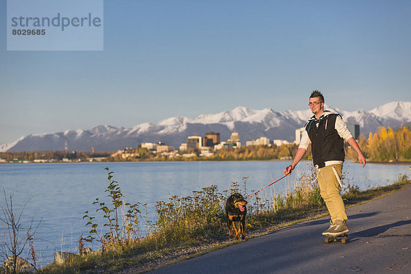 Jugendlicher  Amerika  ziehen  Junge - Person  Sonnenuntergang  folgen  fahren  Küste  Hund  Skateboard  Verbindung  Rottweiler  Alaska  Anchorage