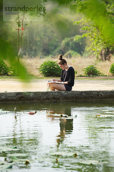 Girl painting beside a lake Chiang mai thailand