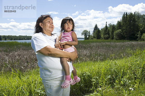 stehend  nebeneinander  neben  Seite an Seite  Fischschwarm  See  Enkeltochter  Großmutter  Feld  Ethnisches Erscheinungsbild  Kanada  Ontario