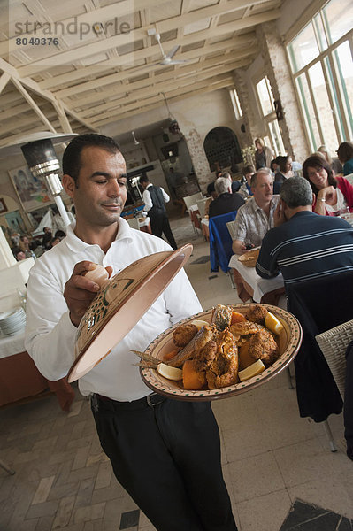 Waiter with tajine  Houmt Souq  Djerba Tunisia