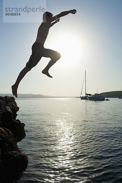 Felsbrocken  nebeneinander  neben  Seite an Seite  Mann  Strand  Meer  springen  Ibiza  Spanien