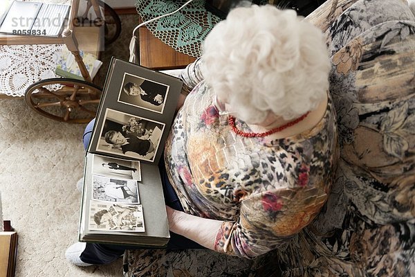 Alte Frau schaut in ein Fotoalbum