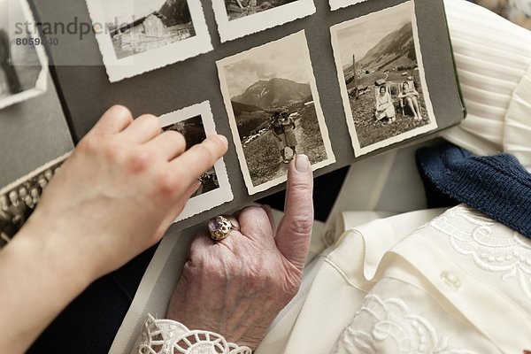 Alte Frau zeigt ein Fotoalbum  close-up