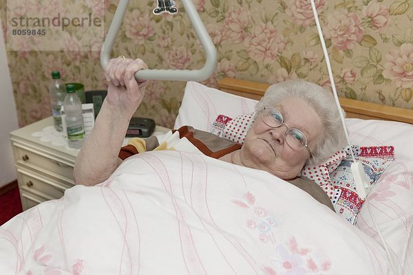 Alte Frau liegt im Krankenbett  Portrait