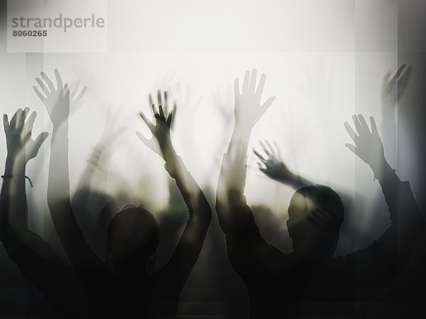 Silhouette von Personen mit erhobenen Händen