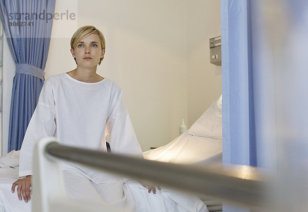 Patient sitzt auf dem Krankenhausbett