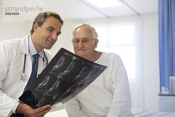 Arzt und Patient bei der Röntgenuntersuchung im Krankenhauszimmer