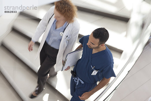Arzt und Krankenschwester gehen auf Krankenhaustreppe