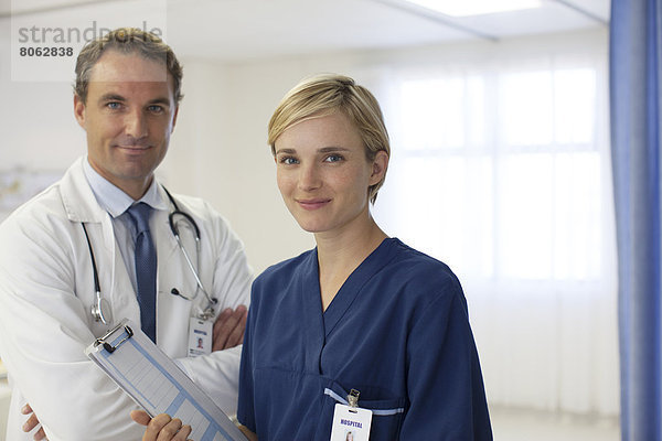 Arzt und Krankenschwester lächeln im Krankenhaus