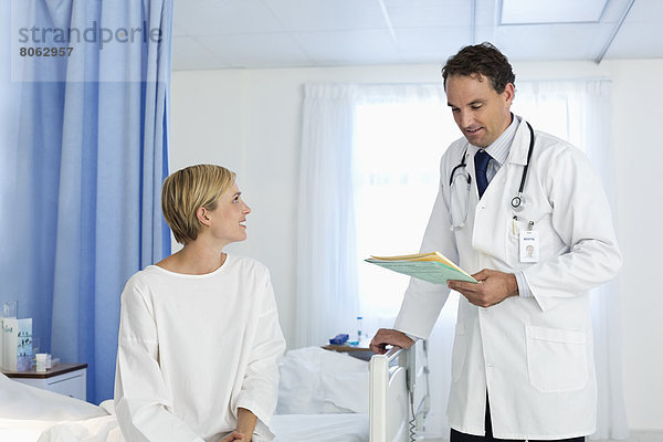 Arzt im Gespräch mit dem Patienten im Krankenhauszimmer