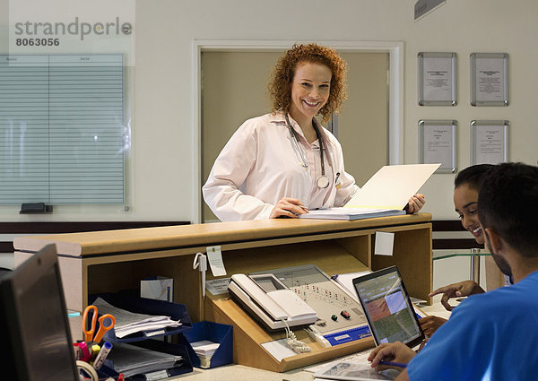 Krankenhauspersonal im Gespräch an der Rezeption