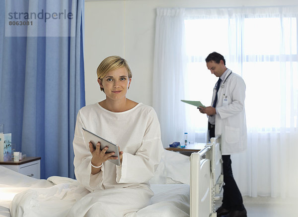 Patient mit Tablet-PC im Krankenhauszimmer
