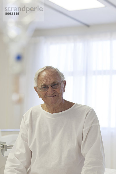 Älterer Patient lächelt im Krankenhauszimmer