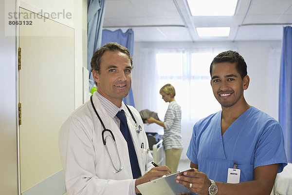 Arzt und Krankenschwester sprechen im Krankenhauszimmer