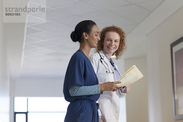 Arzt und Krankenschwester sprechen im Krankenhausflur