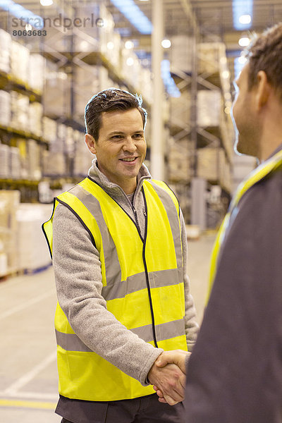 Arbeiter beim Händeschütteln im Lager