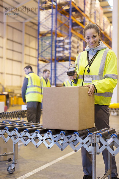 Arbeiter-Scanning-Box auf Förderband im Lager