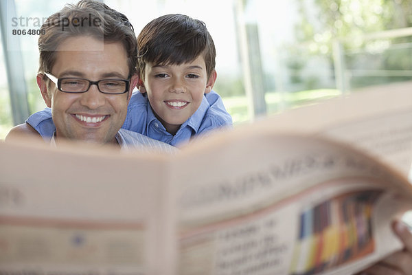 Vater und Sohn lesen gemeinsam Zeitung