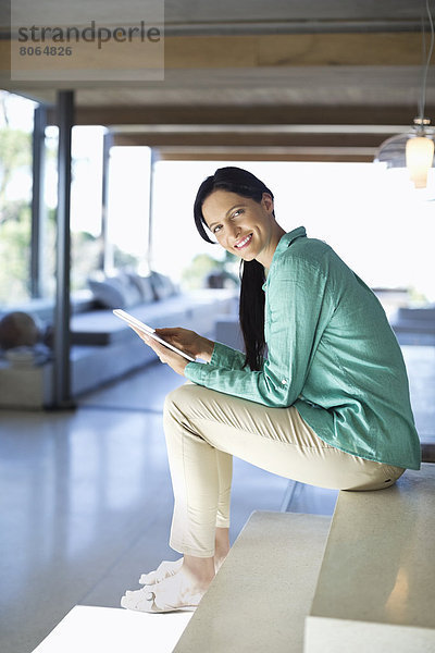 Frau mit Tablet-Computer auf Stufen